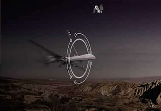 A military drone flies over a desert landscape with digital targeting and signal interference graphics, representing electronic warfare and NAVWAR signal control technology.